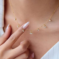 Crystal cherry charm necklace worn by model close up with hand