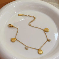 Gold shell charm bracelet close up